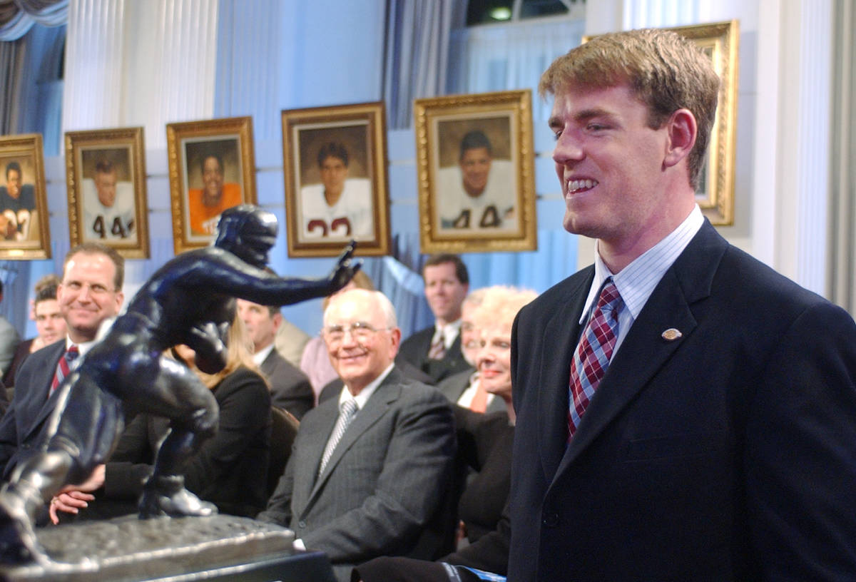 FILE - USC quarterback Carson Palmer, right, smiles at the Heisman Trophy after being named the ...