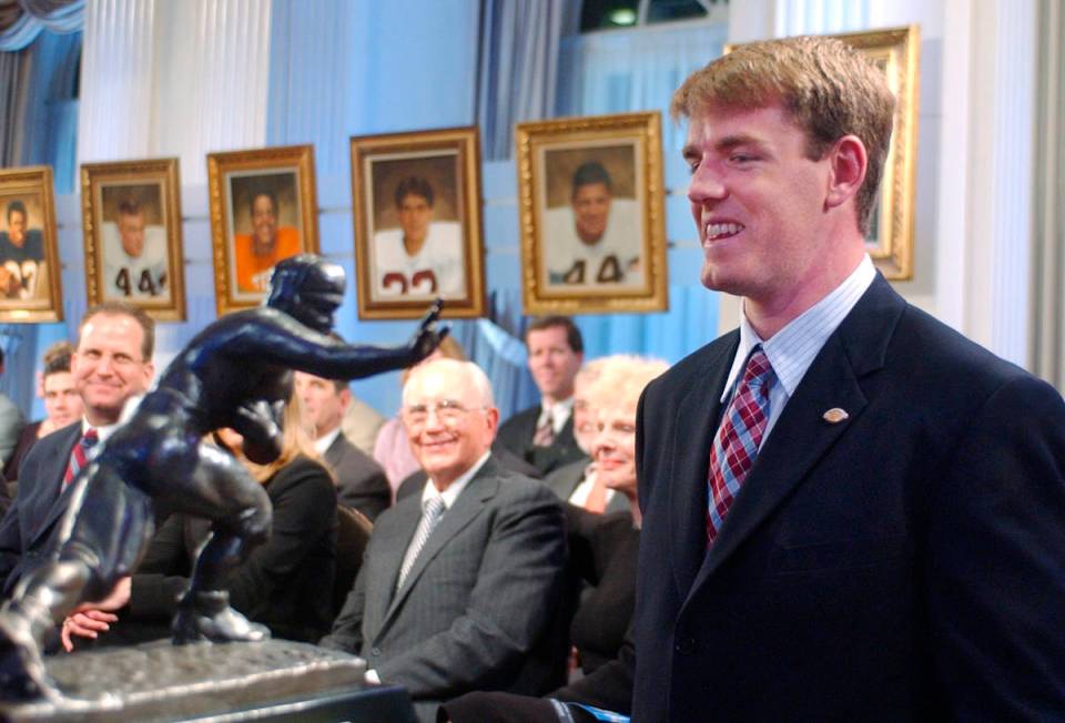 FILE - USC quarterback Carson Palmer, right, smiles at the Heisman Trophy after being named the ...