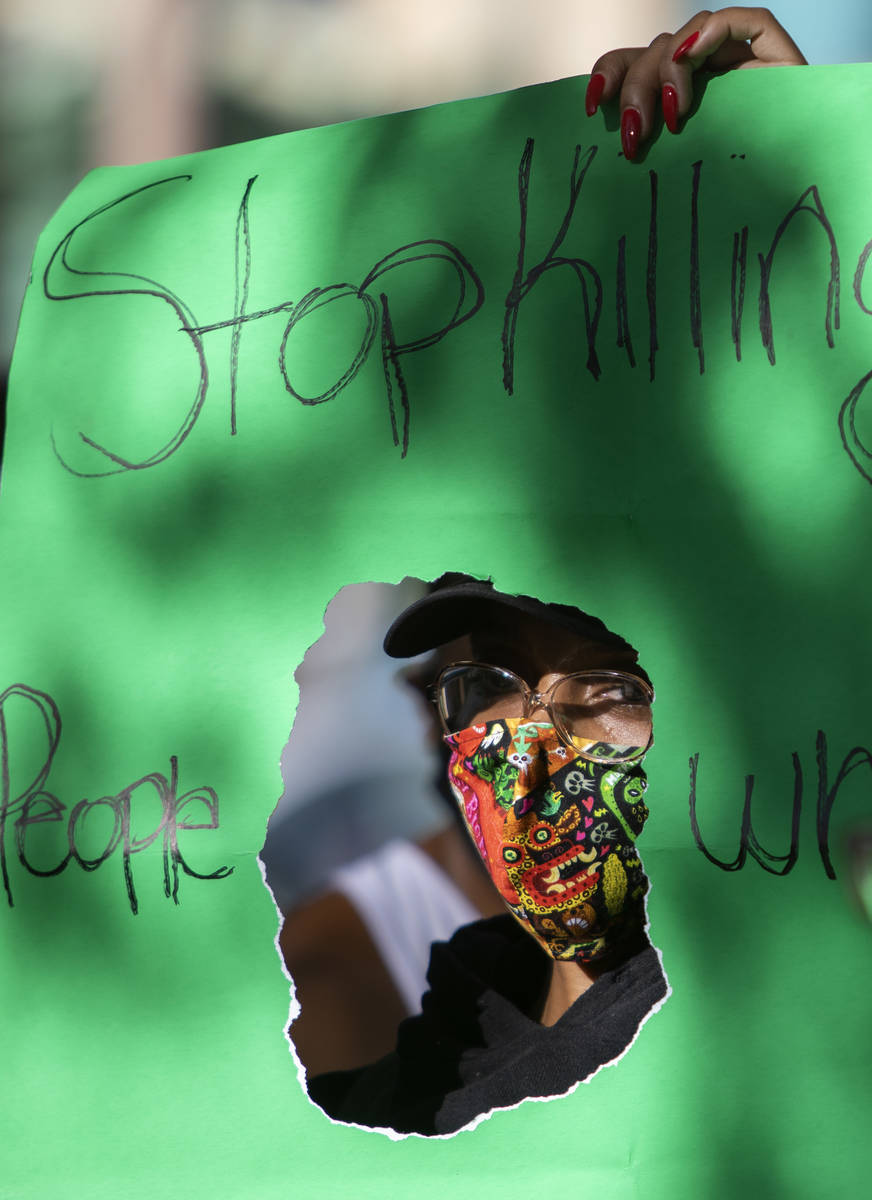 Jameelah Lewis holds a sign reading "stop killing people who look like me" as a protest against ...