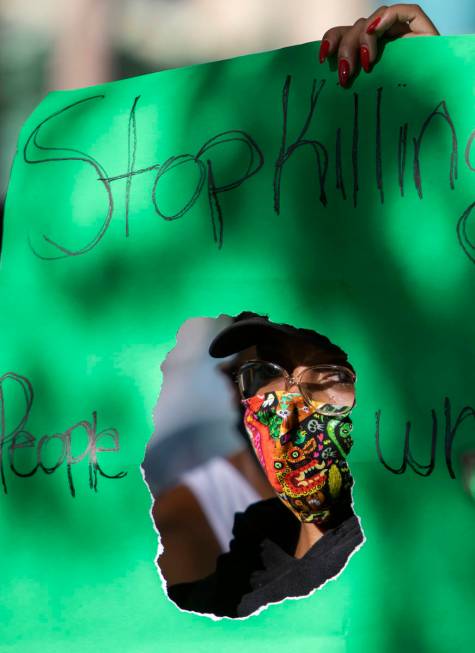Jameelah Lewis holds a sign reading "stop killing people who look like me" as a protest against ...