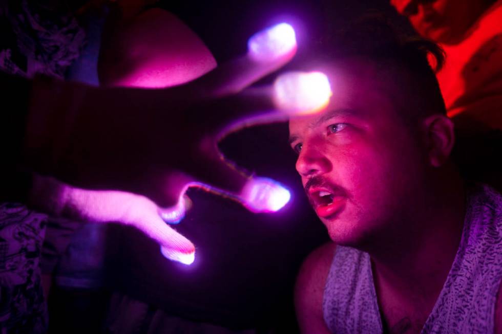 An concert goer enjoys a light show at Insomniac presents Deadmau5 at The Downtown Las Vegas Ev ...