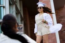 Keamya Williams' cap and gown blows in the wind while she poses for her friend Semara Williams ...