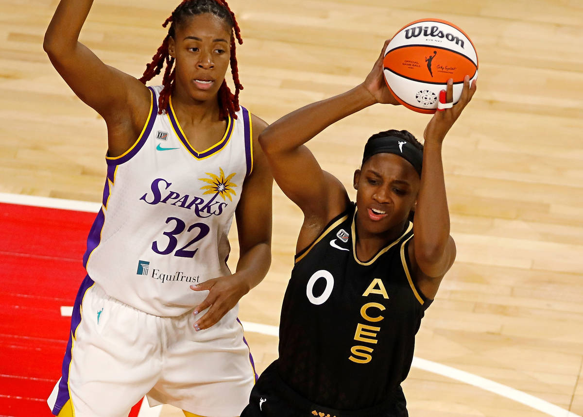 Las Vegas Aces guard Jackie Young (0) looks to pass against Los Angeles Sparks guard Bria Holme ...