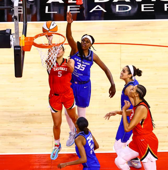 Las Vegas Aces' Dearica Hamby (5) goes to the basket under pressure from Connecticut Sun's Jonq ...