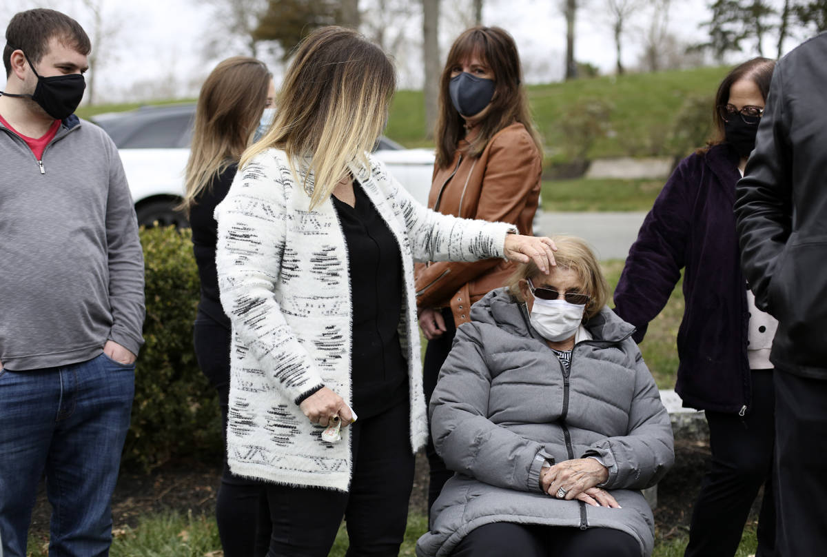 Michelle Pepe uses her hand to brush hair from the face of her mother, Phyllis Rubin, while gat ...