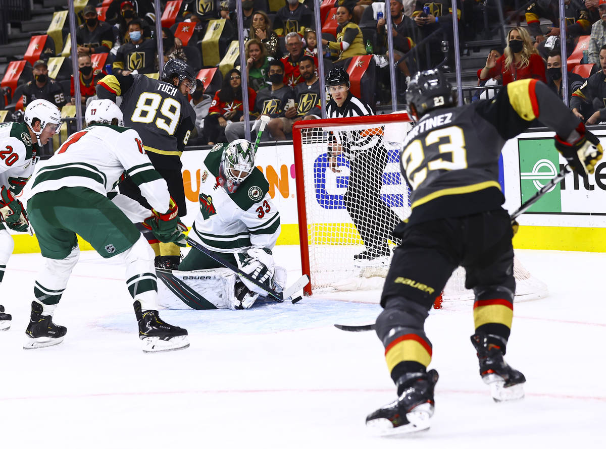 Minnesota Wild goaltender Cam Talbot (33) looks to stop a puck under pressure from Golden Knigh ...