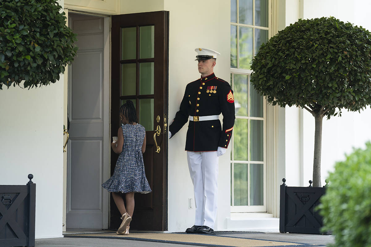 A Marine holds the door as Gianna Floyd, the daughter of George Floyd, walks into the White Hou ...