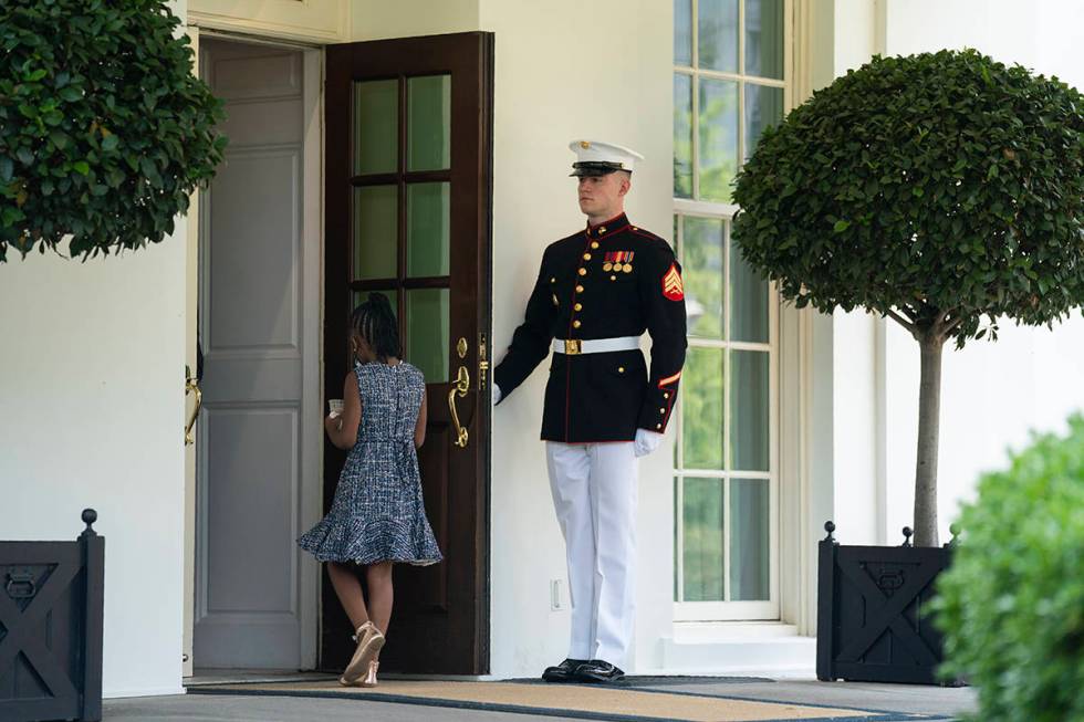 A Marine holds the door as Gianna Floyd, the daughter of George Floyd, walks into the White Hou ...