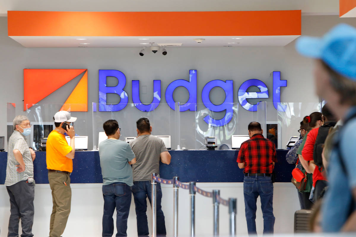 Travelers wait to get a rental car at a Budget car rental in the McCarran Rent-A-Car Center in ...