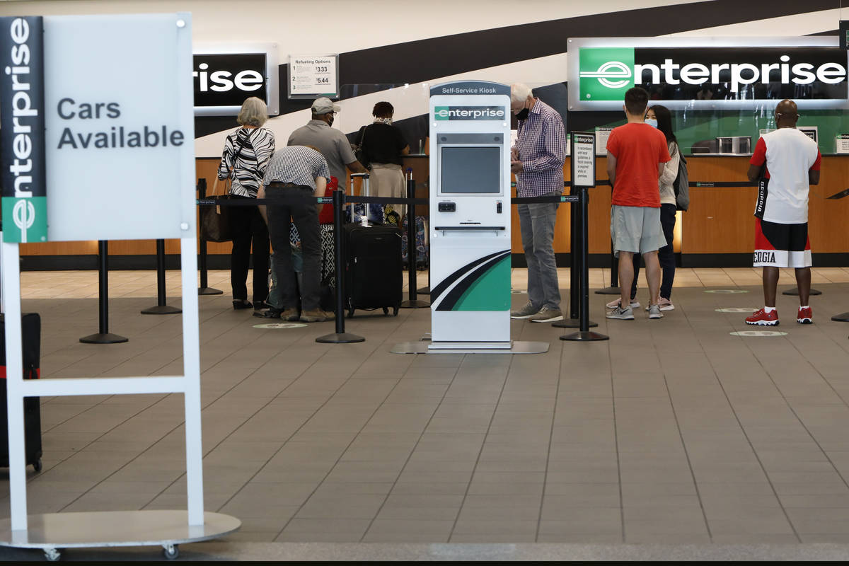 Travelers wait to get a rental car at an Enterprise car rental in the McCarran Rent-A-Car Cente ...