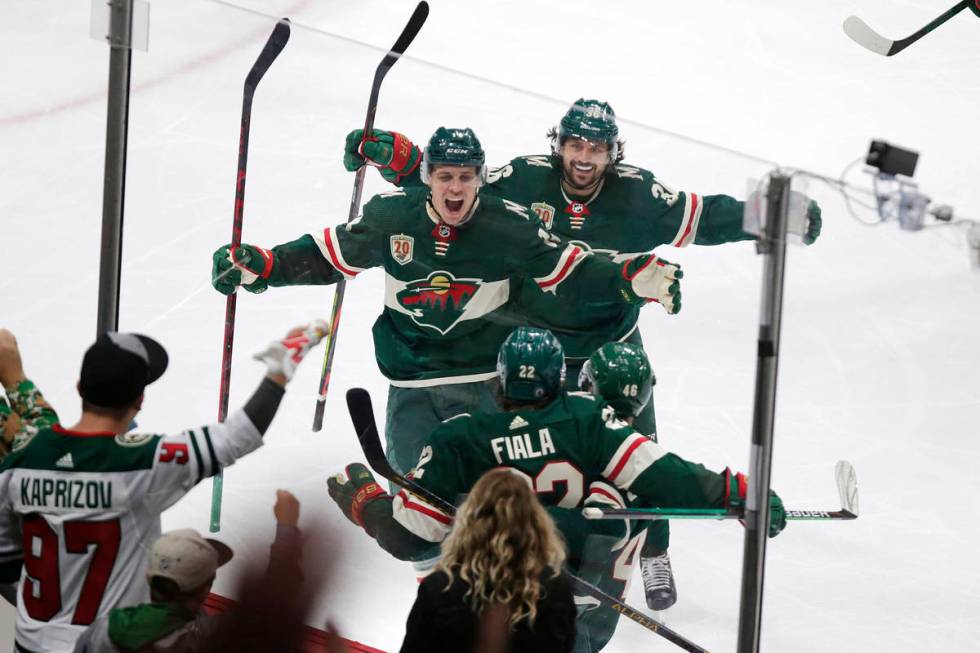 Minnesota Wild left wing Kevin Fiala (22) is congratulated by Joel Eriksson Ek (14) and Mats Zu ...