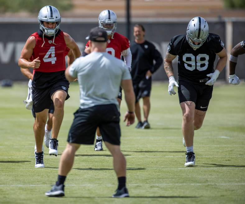 Quarterback Derek Carr (4) sprints with Nathan Peterman (3) and defensive end Maxx Crosby (98) ...
