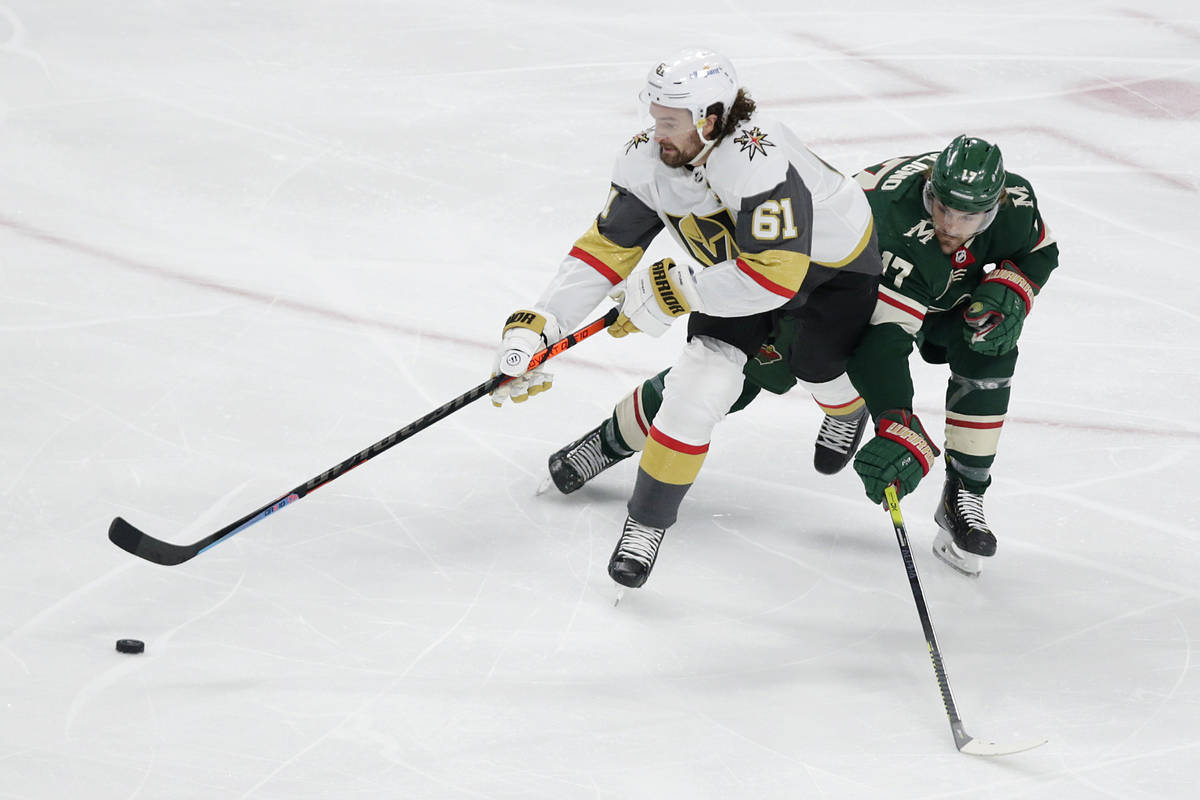 Vegas Golden Knights right wing Mark Stone (61) controls the puck next to Minnesota Wild left w ...