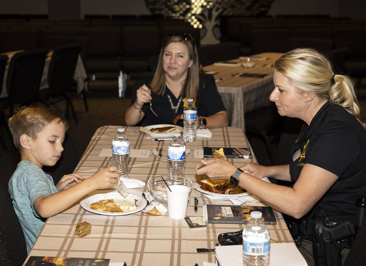 Luke Teis, 7, eat breakfast with Metropolitan Police Department Sgt. Stephanie Ward, right, and ...