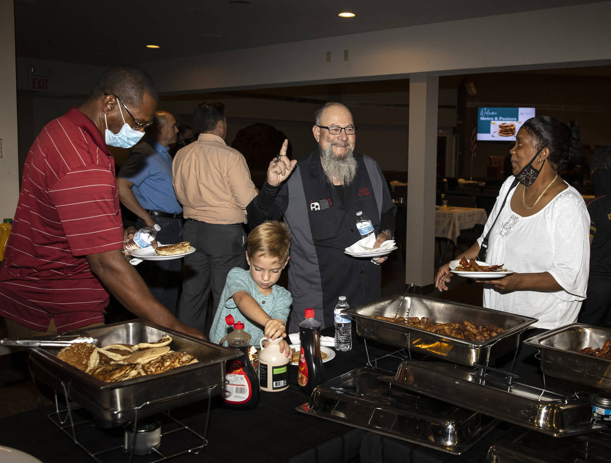 Luke Teis, 7, second from left, and Pastor Ray Reeder, second from right, are in the breakfast ...