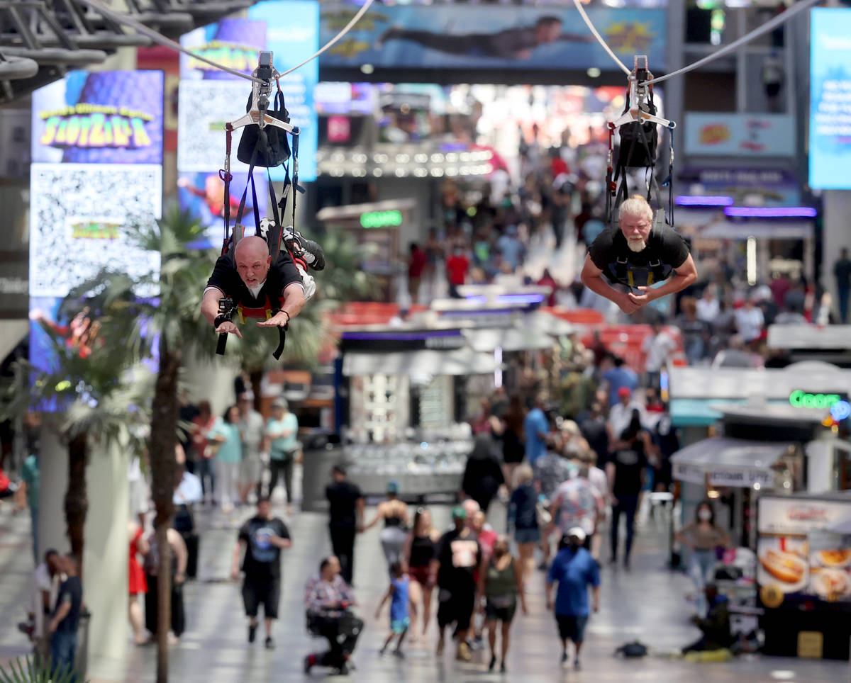 Billy Hill of Henderson, left, and Tony Cox of Las Vegas ride the zip line during a Slotzilla h ...