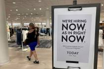 A customer walks behind a sign at a Nordstrom store seeking employees, Friday, May 21, 2021, in ...