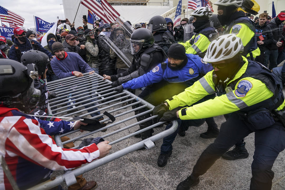 In this file photo from Wednesday Jan. 6, 2021, Trump supporters beset a police barrier at the ...