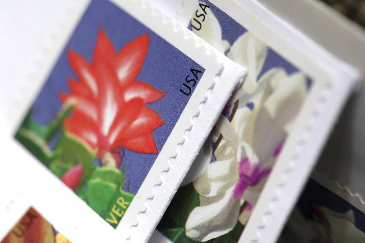 Stamps are attached to envelopes Friday, May 28, 2021, in Washington. The U.S. Postal Service i ...
