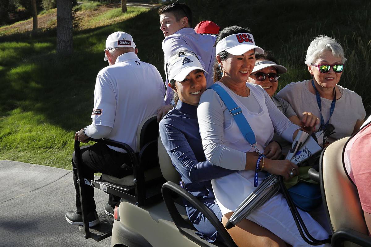 Danielle Kang of USA, center, holds her mother Grace Lee while riding on a cart to the clubhous ...