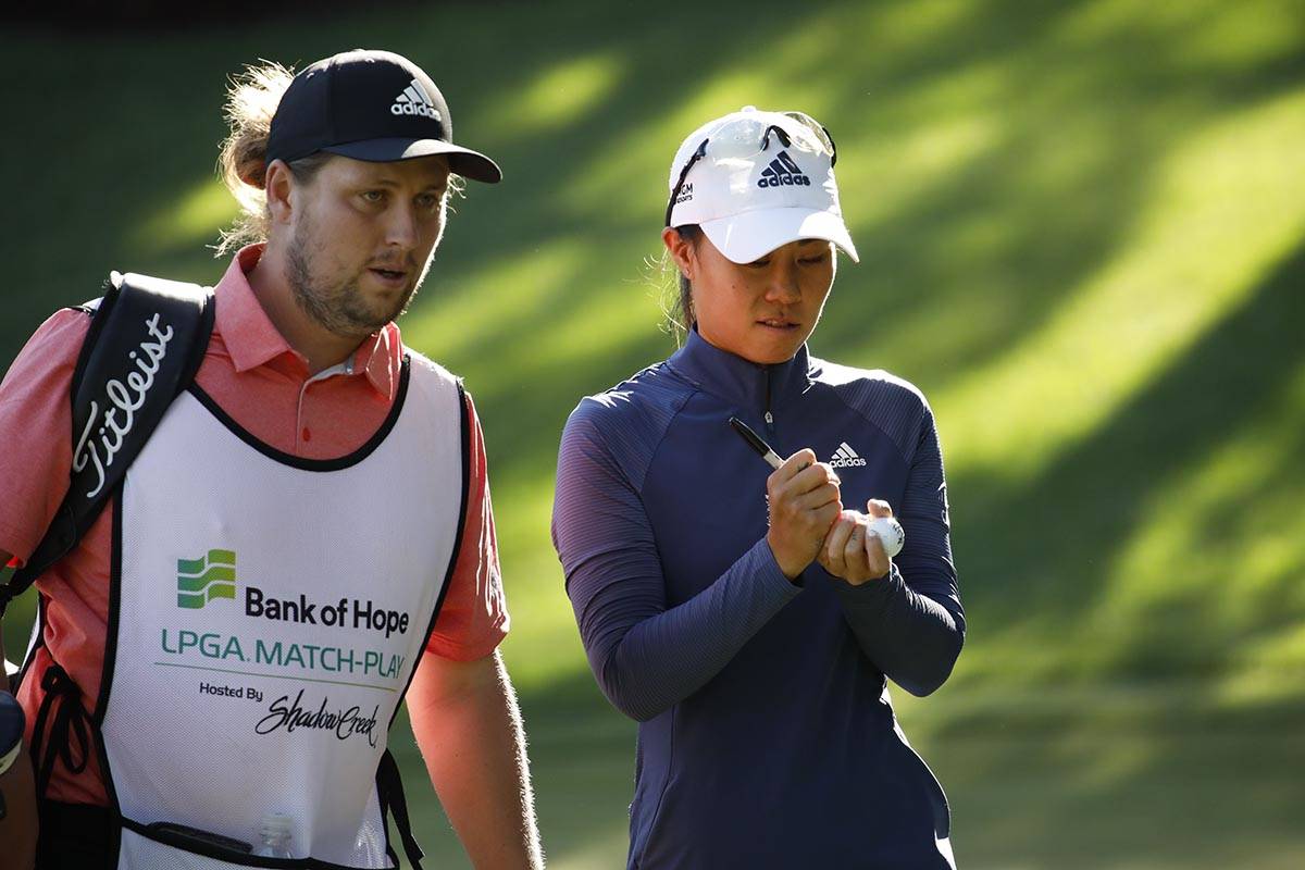 Danielle Kang of USA, signs balls with her caddie after finishing the 15th hole during the thir ...