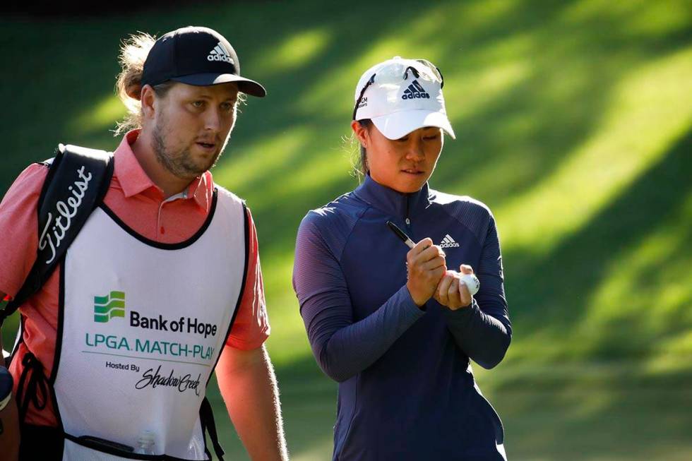 Danielle Kang of USA, signs balls with her caddie after finishing the 15th hole during the thir ...
