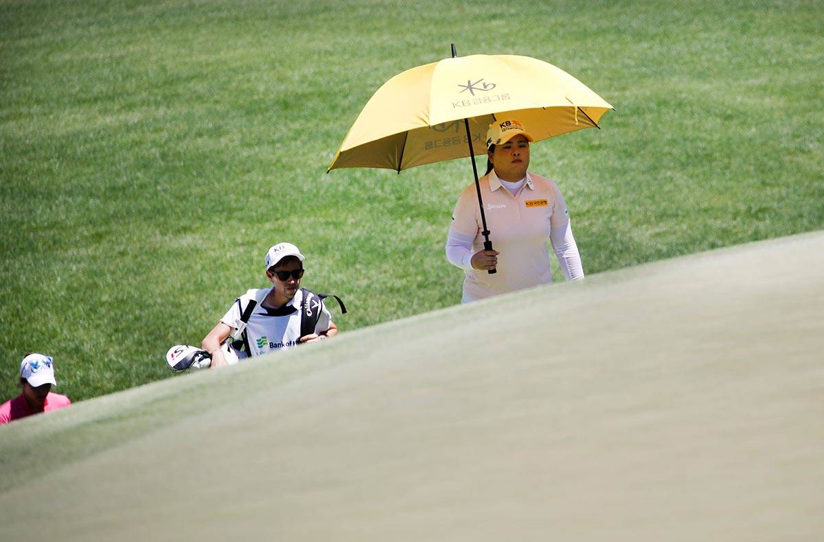 Inbee Park of South Korea, right, walks to the second green with Gaby Lopez of Mexico, left, an ...