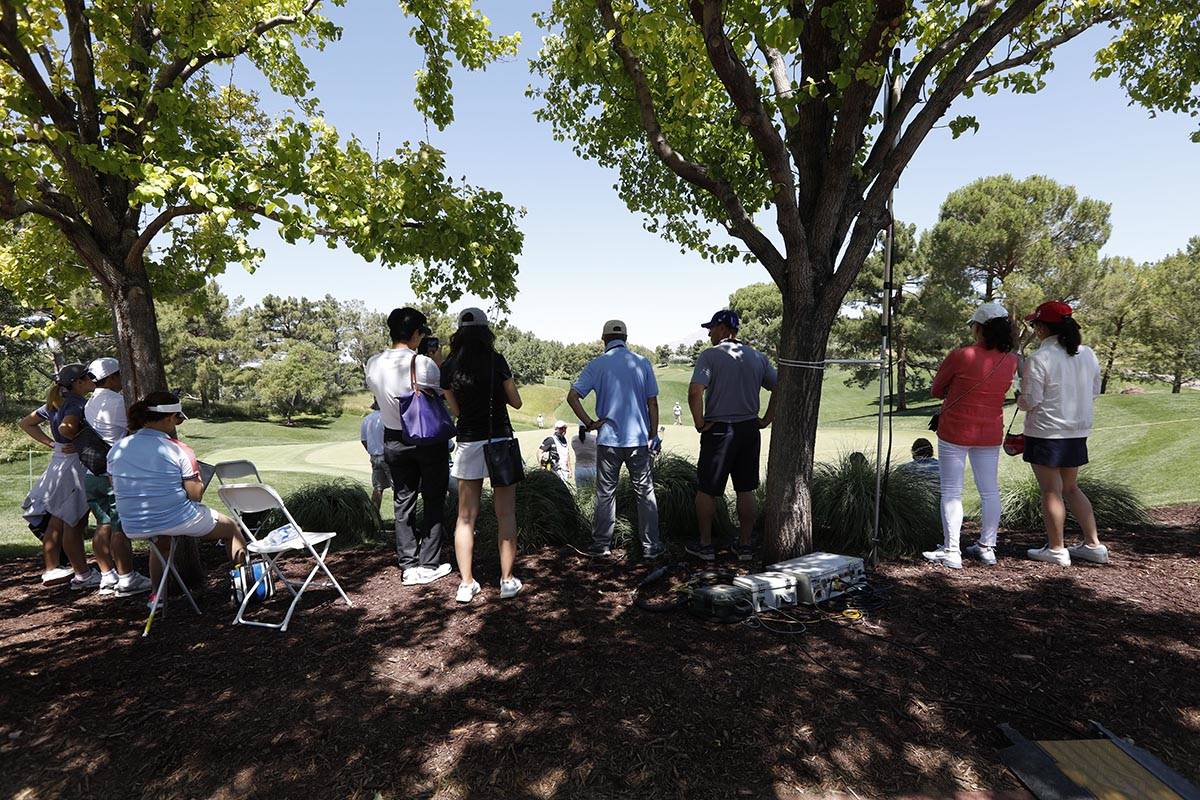 The gallery stays under the trees to avoid the strong sun during the third round of the Bank of ...