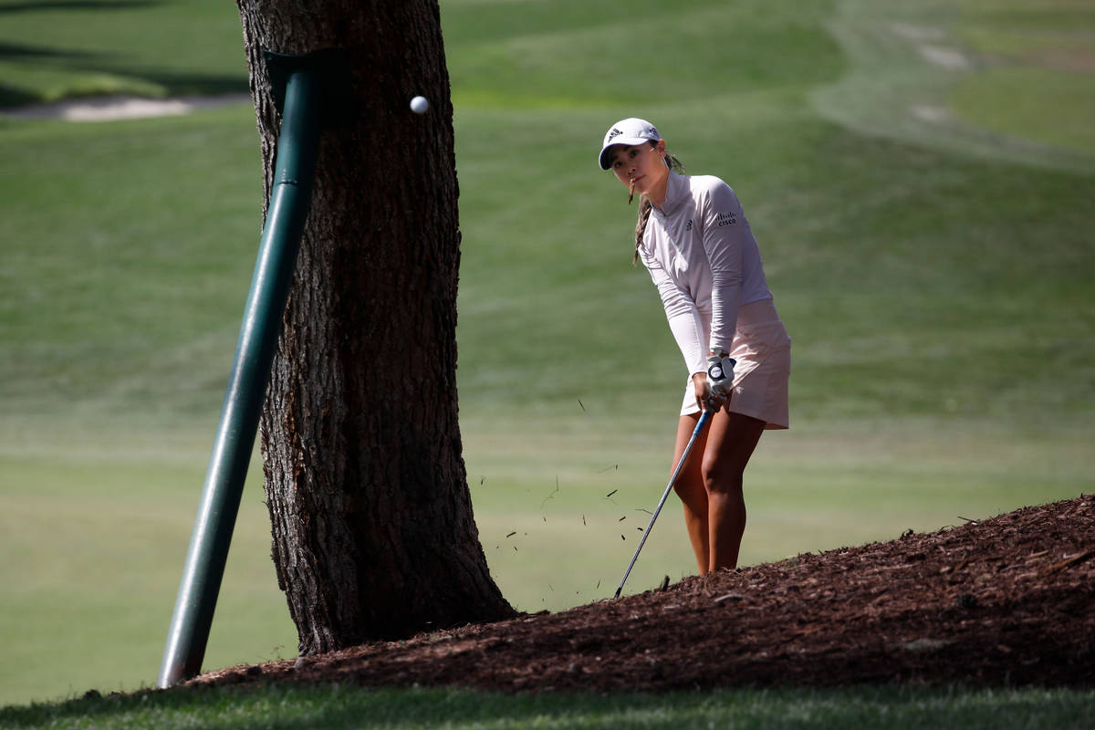 Danielle Kang hits out from behind a tree on the 14th hole during the quarter final round of t ...