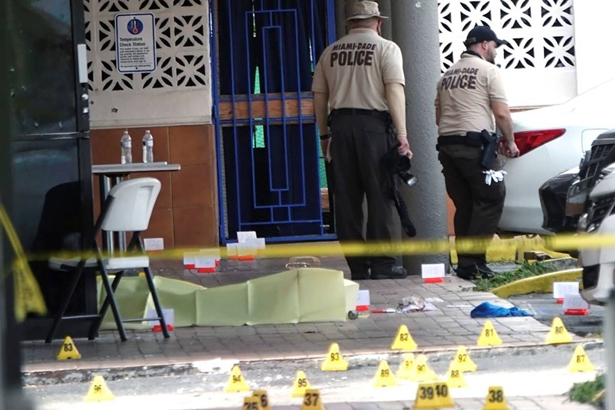 Miami-Dade Police work the scene of a shooting outside a banquet hall near Hialeah, Fla., Sunda ...