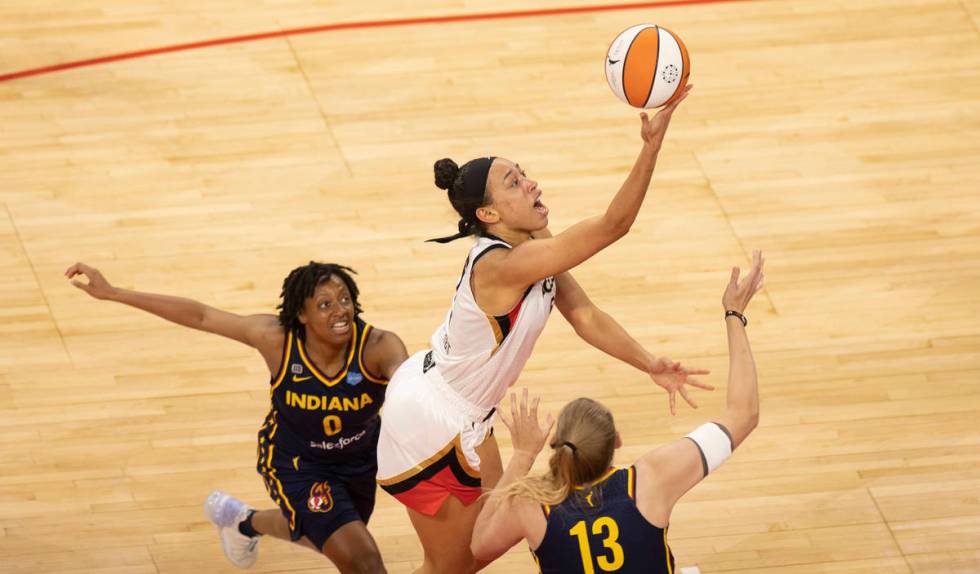 Las Vegas Aces forward Dearica Hamby (5) slices past Indiana Fever guard Kelsey Mitchell (0) an ...