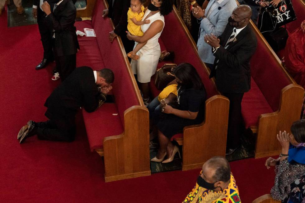 Rev. John R. Faison, Sr. kneels in prayer after preaching at a joint service for the centennial ...