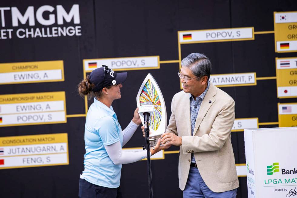 Kevin Kim, CEO and president of Bank of Hope, right, hands the trophy to Ally Ewing after she w ...