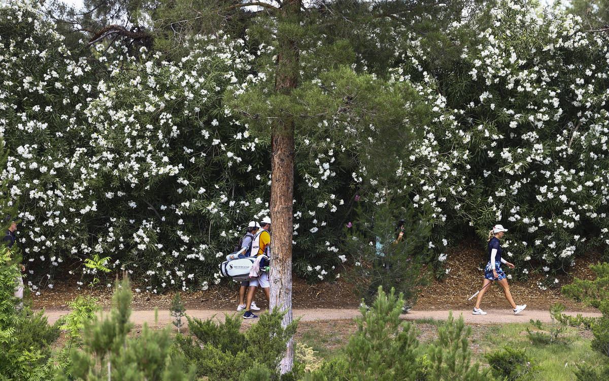 Sophia Popov, right, walks on a path at the fifth hole during the championship round of the Ban ...