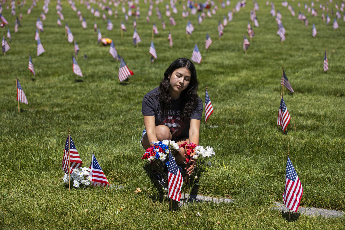 Alysa Arias lays flowers at the grave site of an Air Force veteran she considered Ҭike fa ...