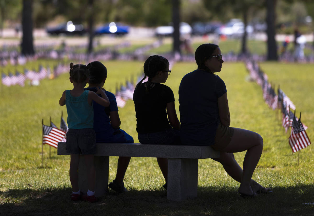 Attendees of a Memorial Day ceremony visit the grave sites of deceased veterans on Monday, May ...