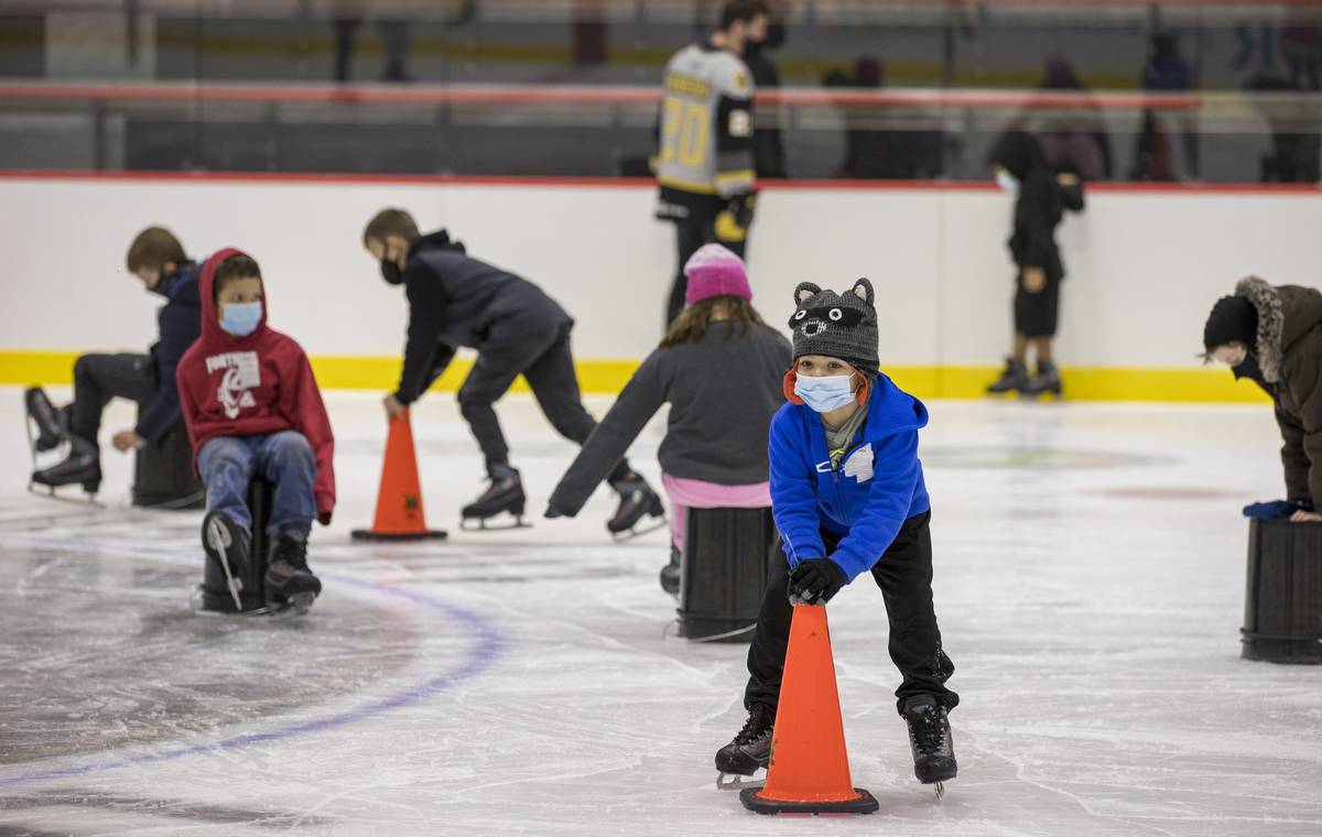 Youngsters with the Battle Born Kids Program use cones and buckets to stay upright on the ice d ...