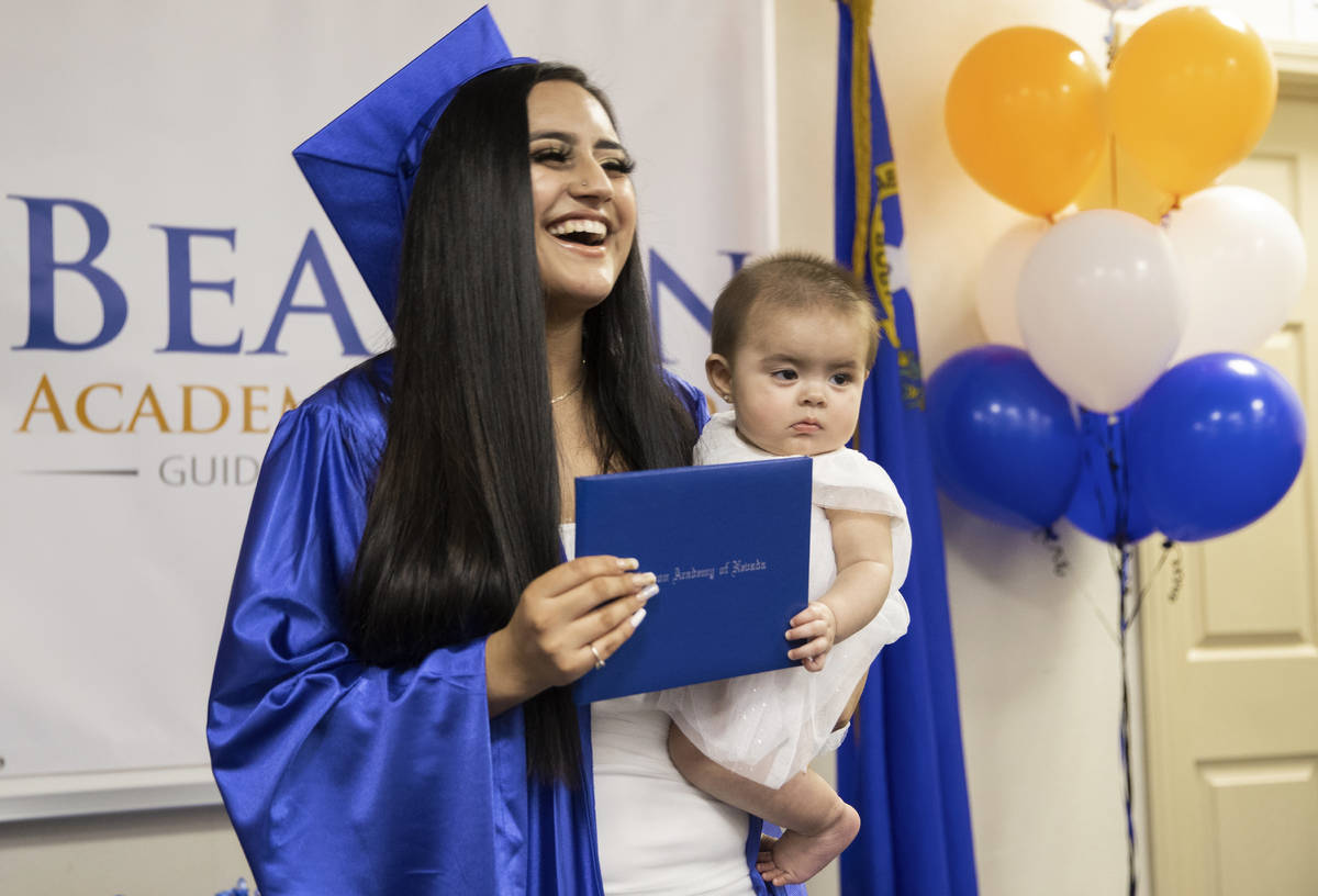 Jennifer Amaya holds her diploma with Violet Montanez, 7 months, during graduation for Beacon A ...