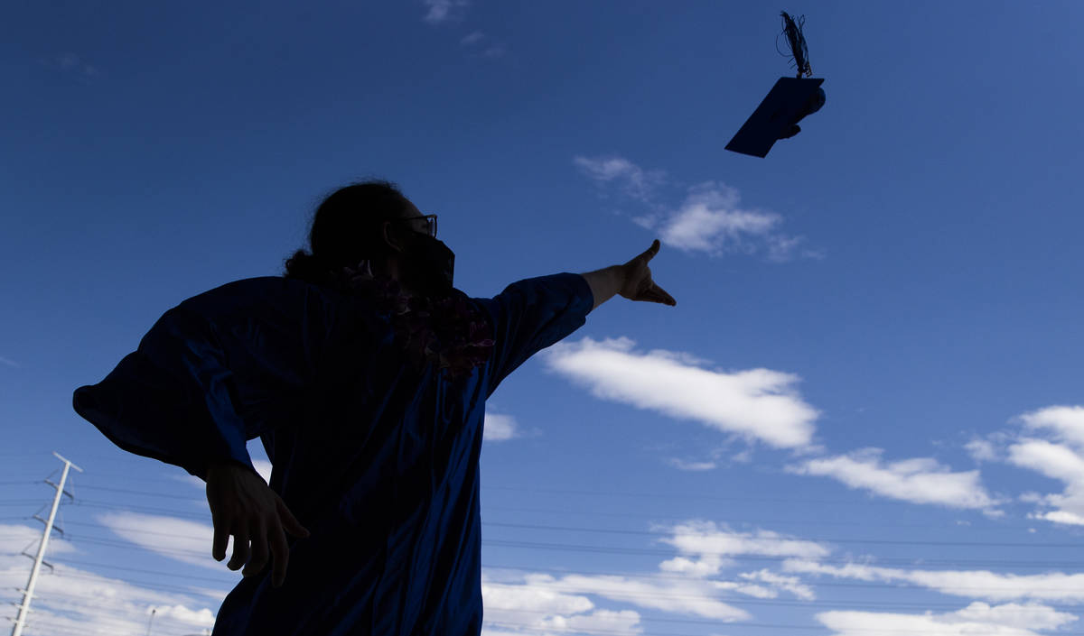 Trey Solares tosses his graduation cap in the parking lot after graduation for Beacon Academy o ...