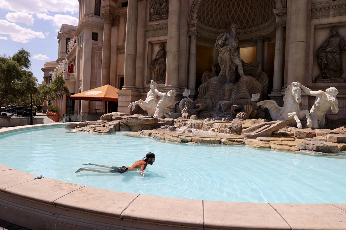 Frank John Laveglia of Las Vegas cools off in a fountain in front of Caesars Palace on the Stri ...
