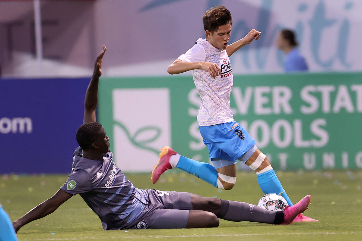 Las Vegas Lights Christian Torres (21) protects the ball as Abdoulaye Cissoko (92) slides in th ...