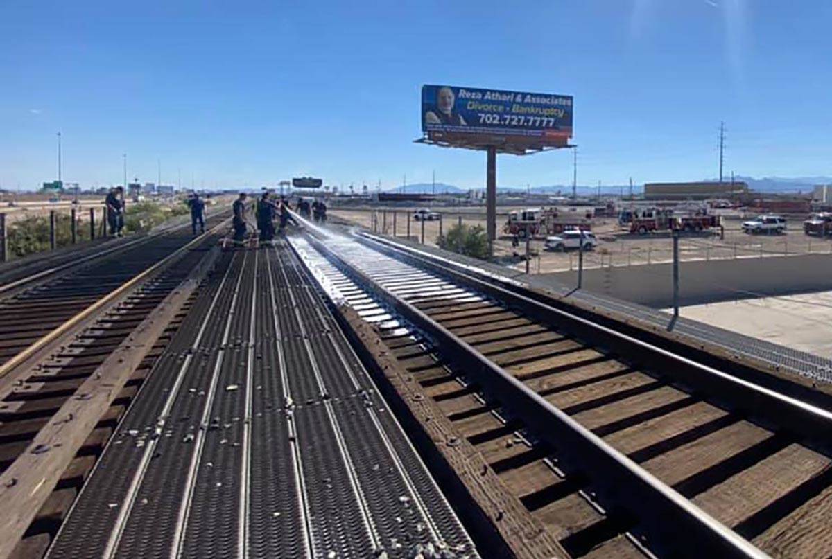 Firefighters spray tracks burned in a fire in North Las Vegas on Saturday, June 5, 2021. (North ...