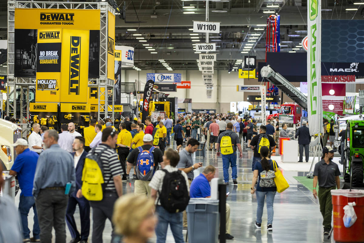 World of Concrete 2021 attendees wander about the displays on the trade-show floor in the West ...