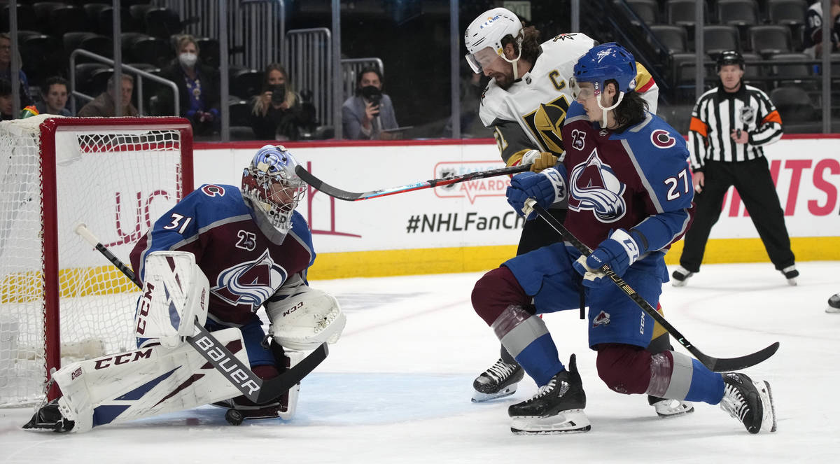 Colorado Avalanche goaltender Philipp Grubauer, left, stops a shot as defenseman Ryan Graves, f ...