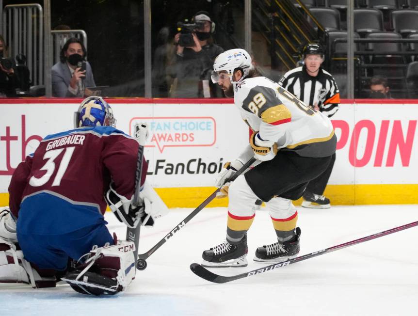 Colorado Avalanche goaltender Philipp Grubauer, left, stops a shot by Vegas Golden Knights righ ...