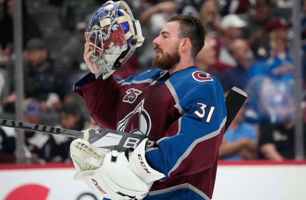 Colorado Avalanche goaltender Philipp Grubauer puts on his mask during a timeout in the first p ...