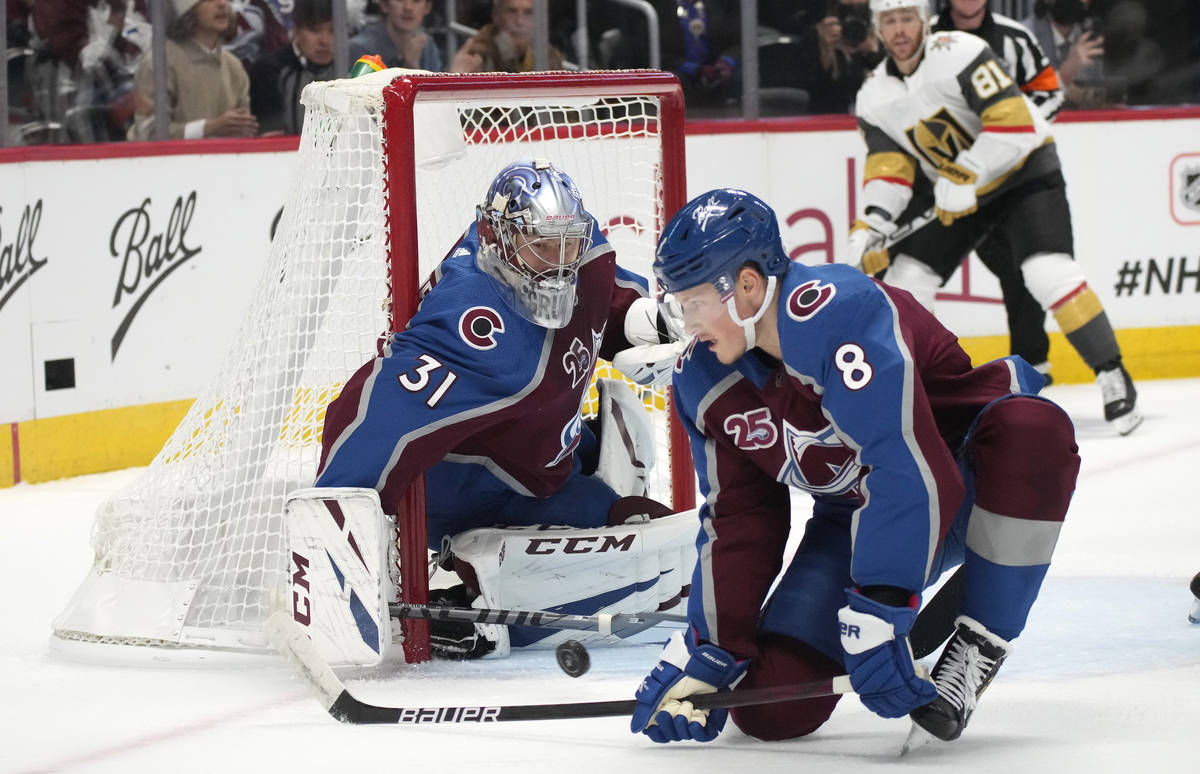 Colorado Avalanche defenseman Cale Makar, front, deflects a shot next to goaltender Philipp Gru ...