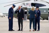 President Joe Biden brushes a cicada from his neck as he and first lady Jill Biden board Air Fo ...