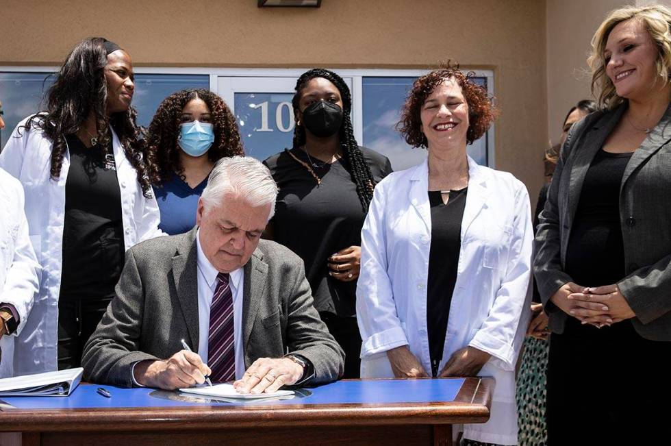 Gov. Steve Sisolak signs Senate Bill # 420, the bill that will provide a public health care opt ...
