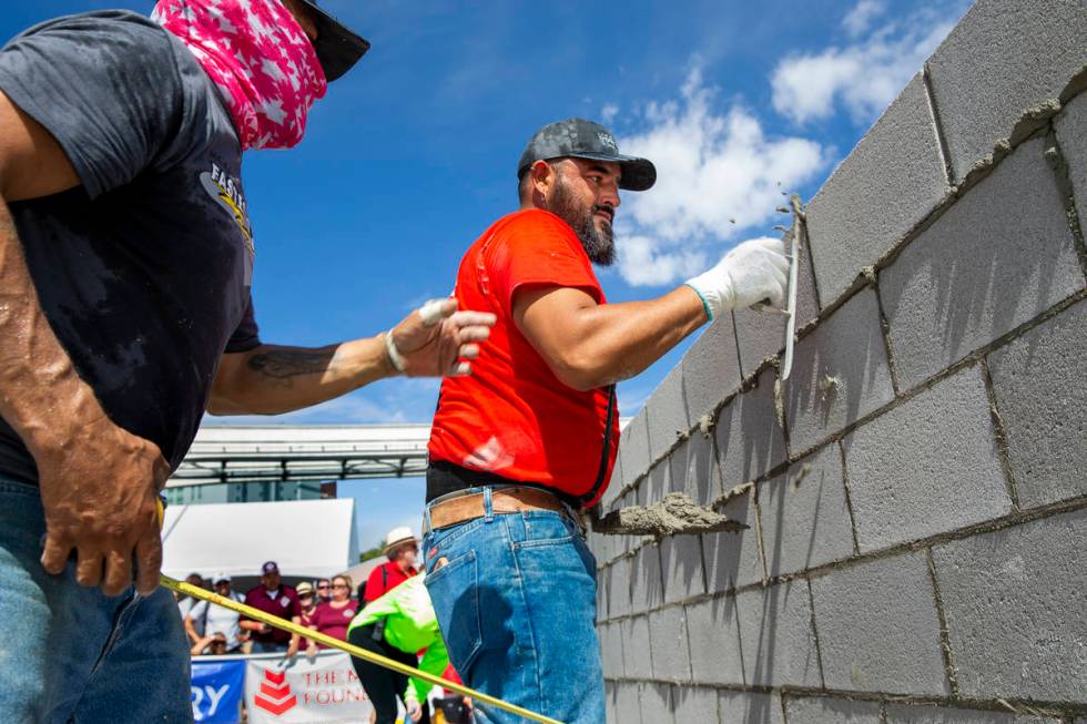Jose Soto, right, and tender Israel Mendoza clean up concrete block in the Fastest Trowel on th ...